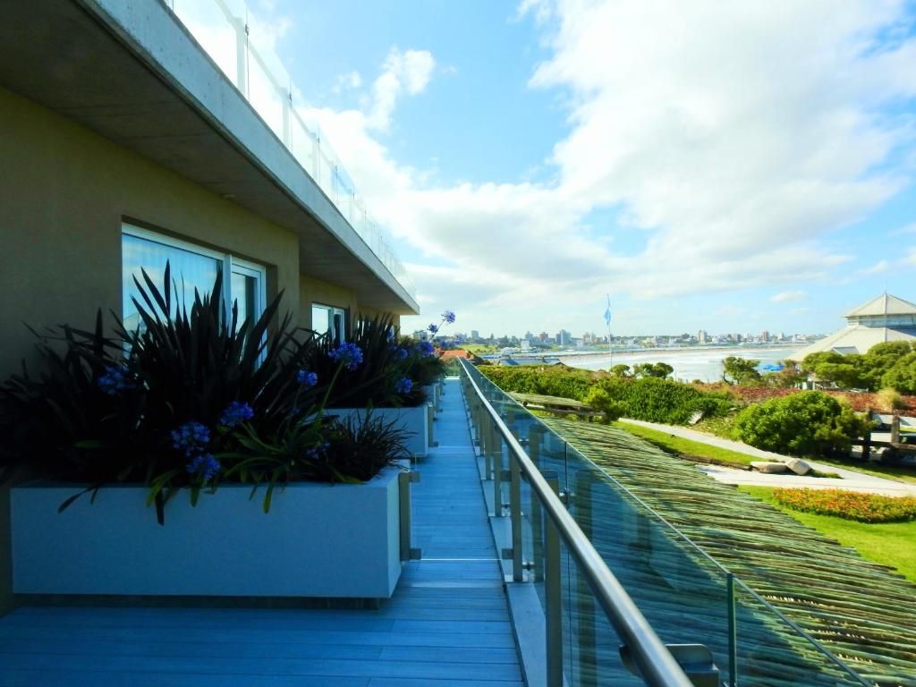 La galería de los balcones sobre el techo verde del complejo, con la costa de Mar del Plata a lo lejos