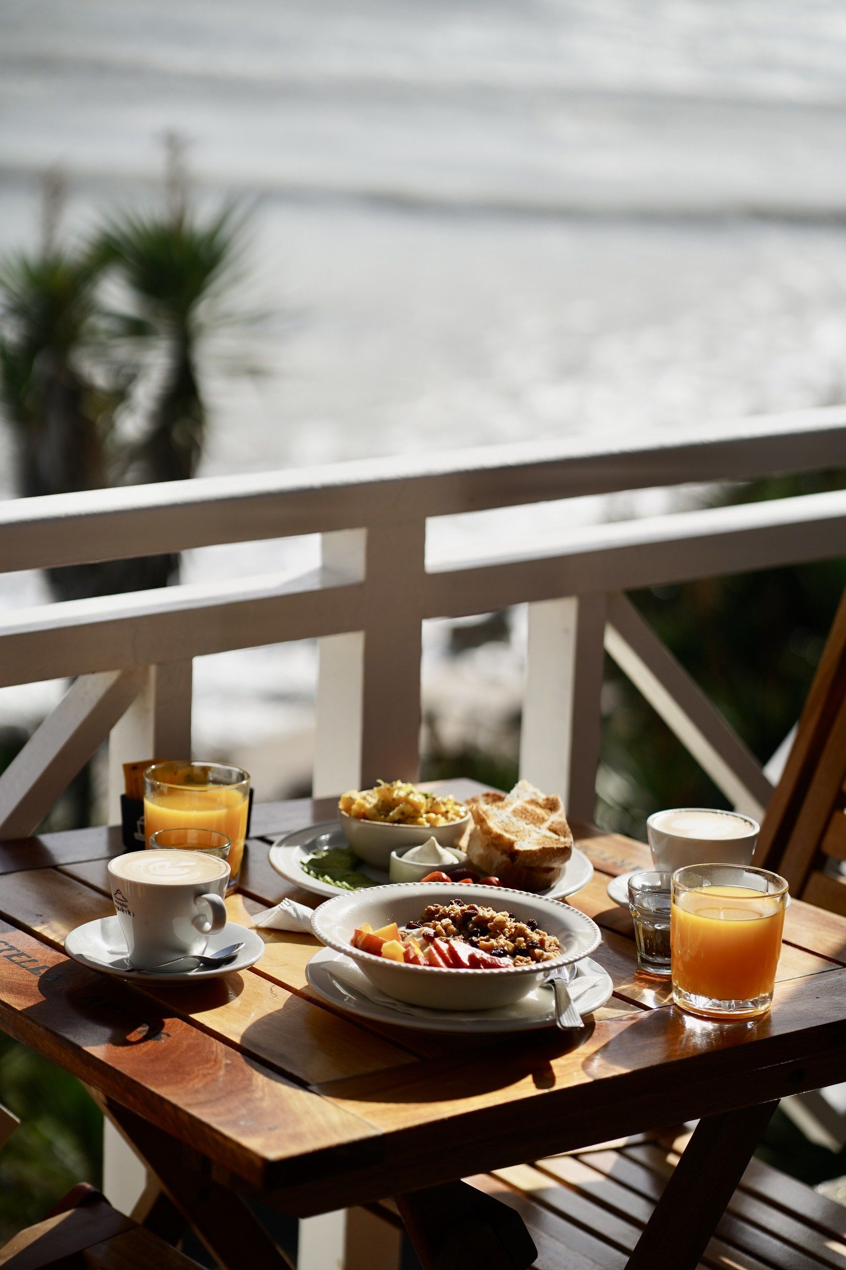 Una mesa servida junto a la baranda, con la playa abajo