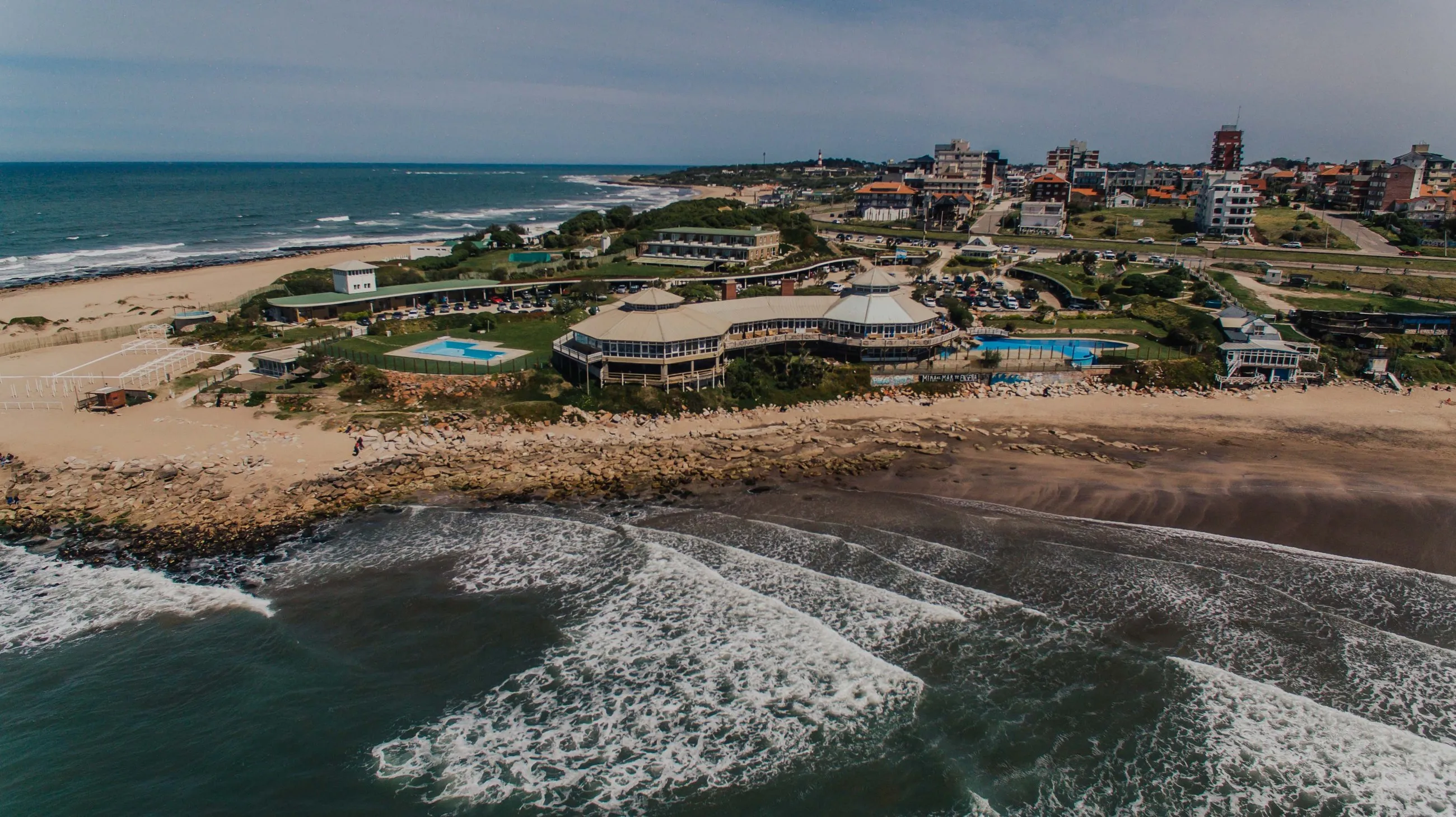El complejo Mirador Waikiki visto desde el mar con un dron: el restaurante, las piletas, el parque y la playa sobre la costa de Mar del Plata